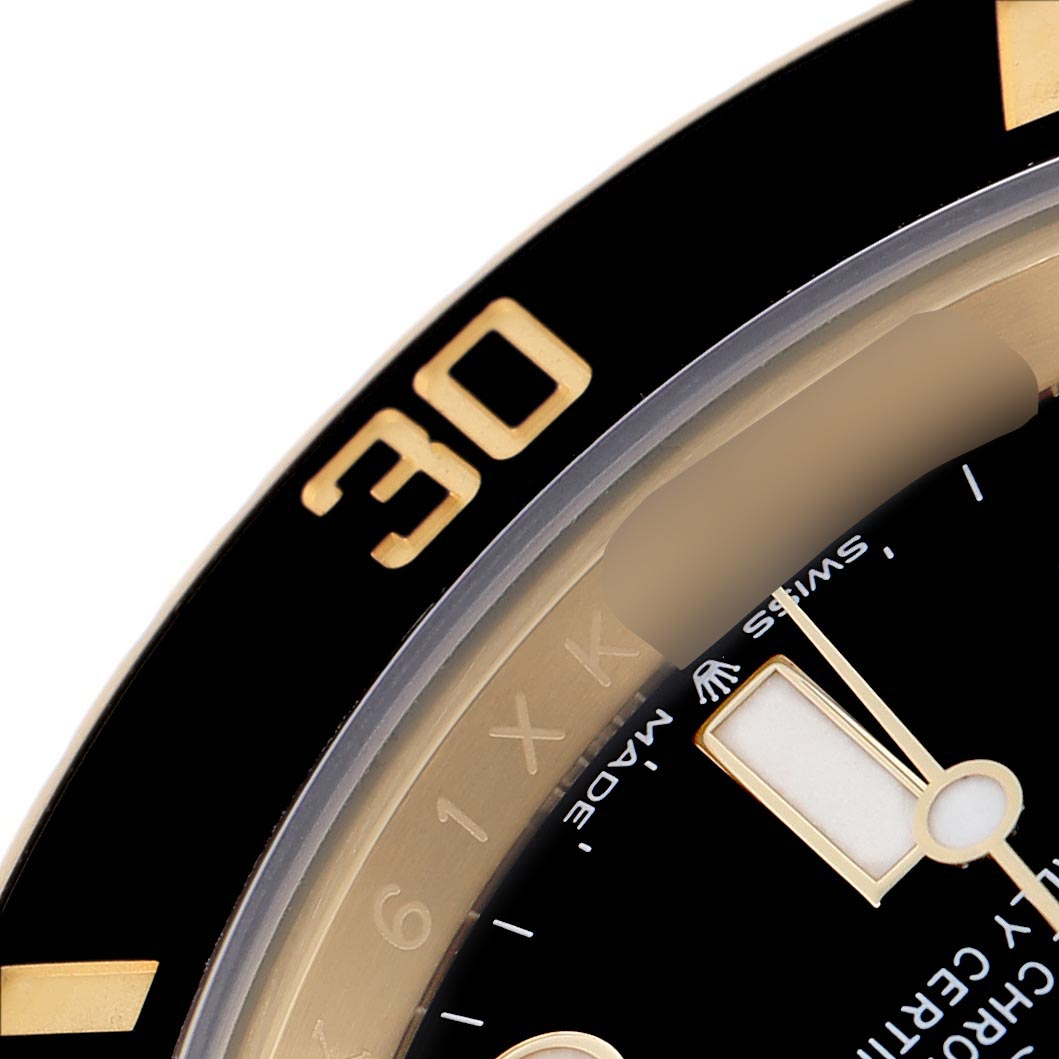The image shows a close-up angle of the Rolex Submariner 126618 Men's Yellow Gold Black Dial's bezel, dial, and part of the minute hand.